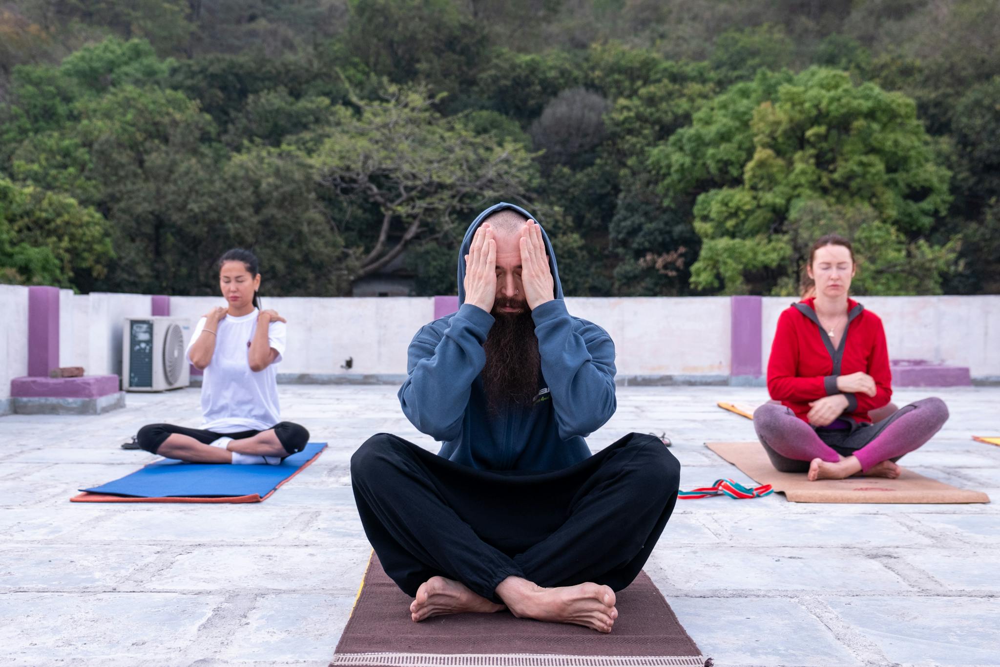 Group of adults practicing yoga meditation outdoors, focusing on mindfulness.